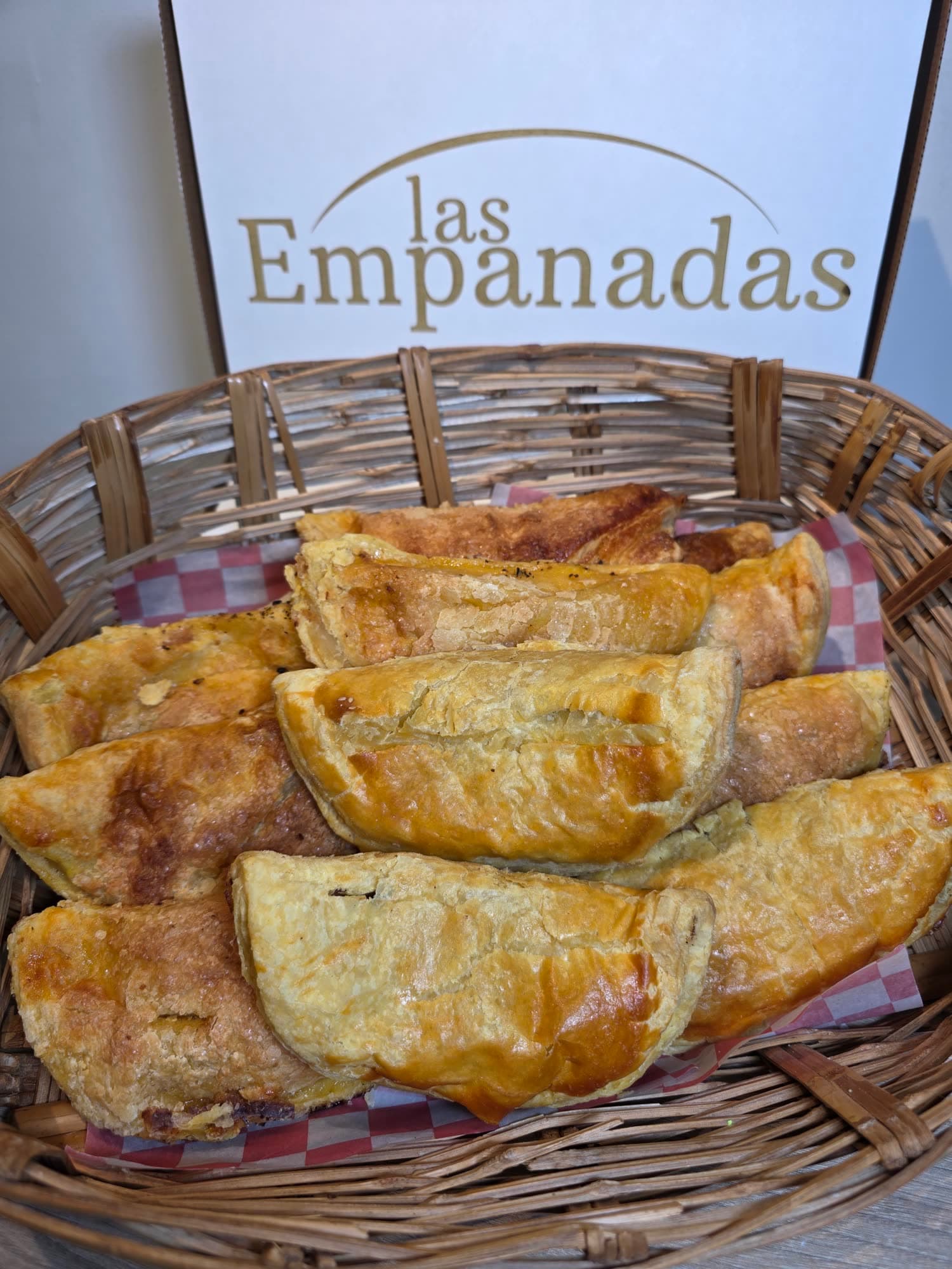 Canasta de pastes frente a una caja de Las Empanadas